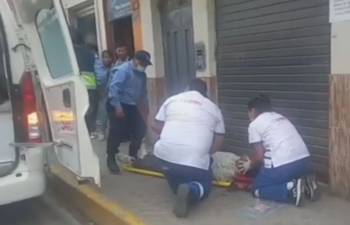 Paramedics tend to a man lying on the curbside in Huanuco, Peru, on Oct. 18, 2022, in a still from video. (AP/Screenshot via The Epoch Times)