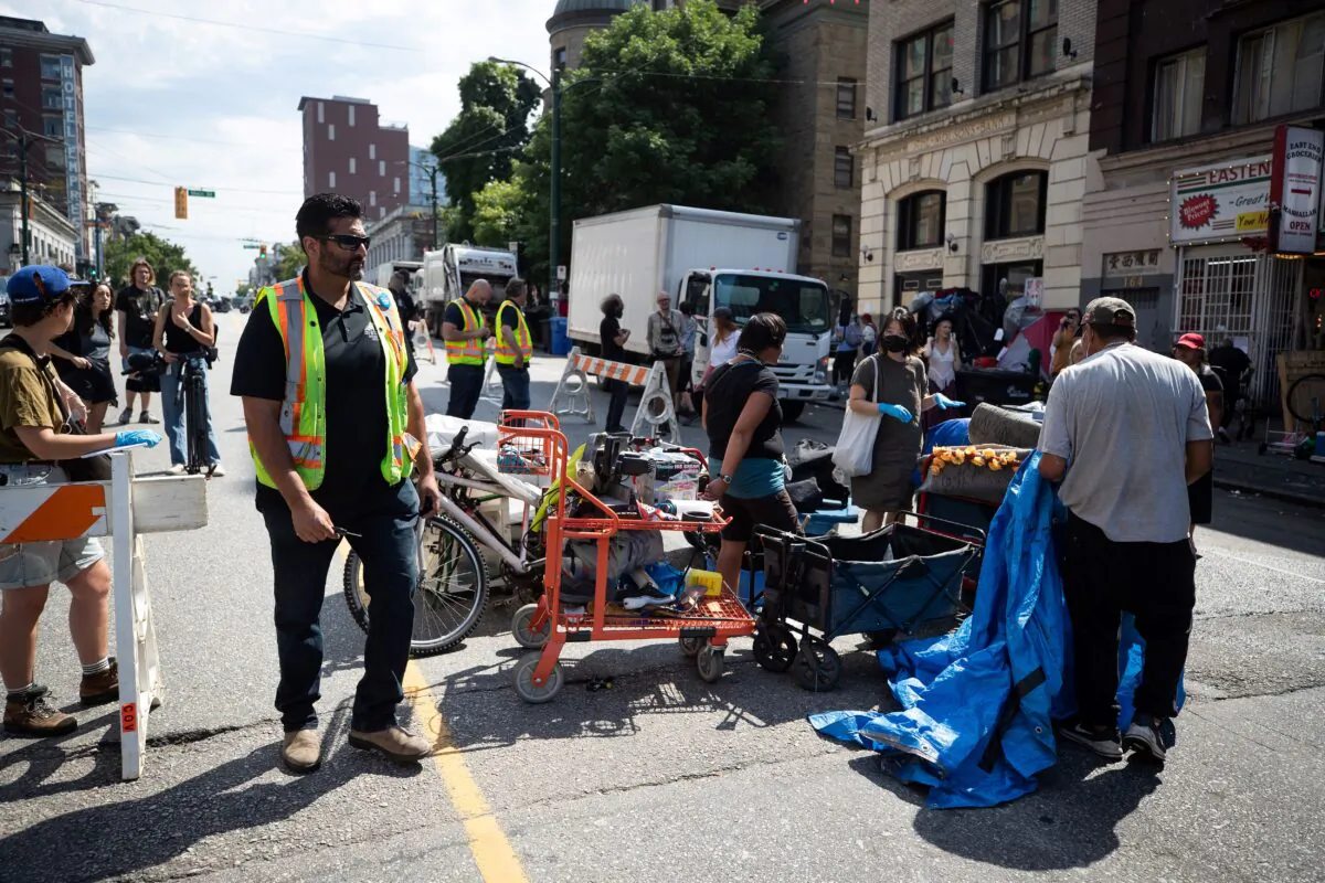 A person's belongings are placed on the street to be moved to storage after his tent was cleared from the sidewalk at a sprawling homeless encampment on East Hastings Street in the Downtown Eastside of Vancouver, on Aug. 9, 2022. (The Canadian Press/Darryl Dyck)