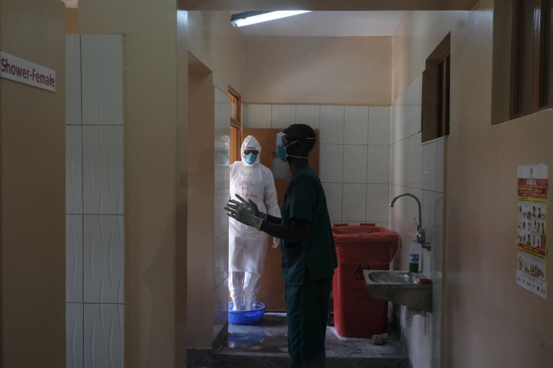 Doctors disinfect themselves after visiting a patient who was in contact with an Ebola victim, in the isolation section of Entebbe Regional Referral Hospital in Entebbe, Uganda, on Oct. 20, 2022. (Hajarah Nalwadda/AP Photo)