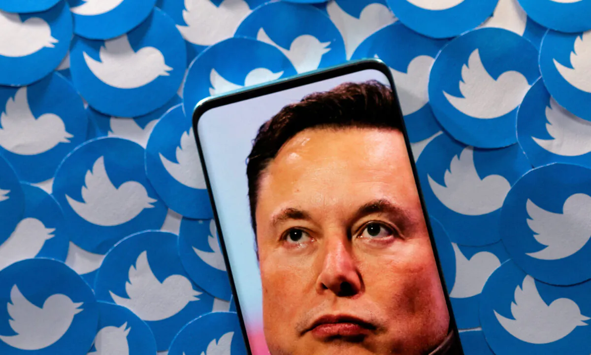 Elon Musk on a smartphone placed on printed Twitter logos on April 28, 2022. (Dado Ruvic/Illustration/Reuters)