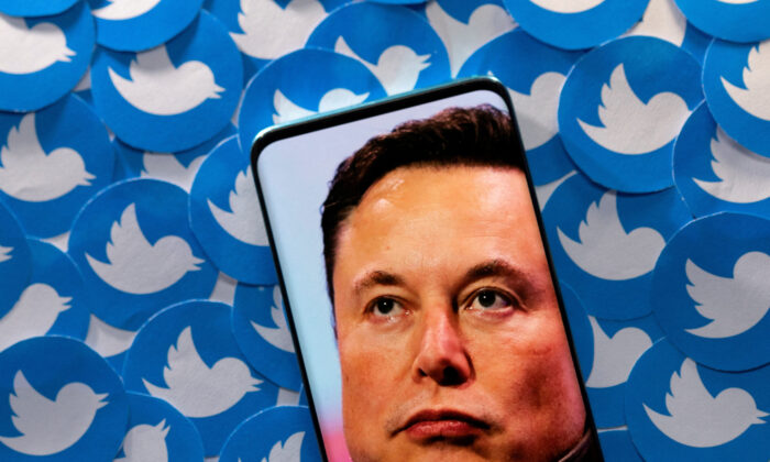 2022 年 4 月 28 日，埃隆·马斯克（Elon Musk）在智能手机上放置在印刷的 Twitter 徽标上。（Dado Ruvic/Illustration/Reuters）