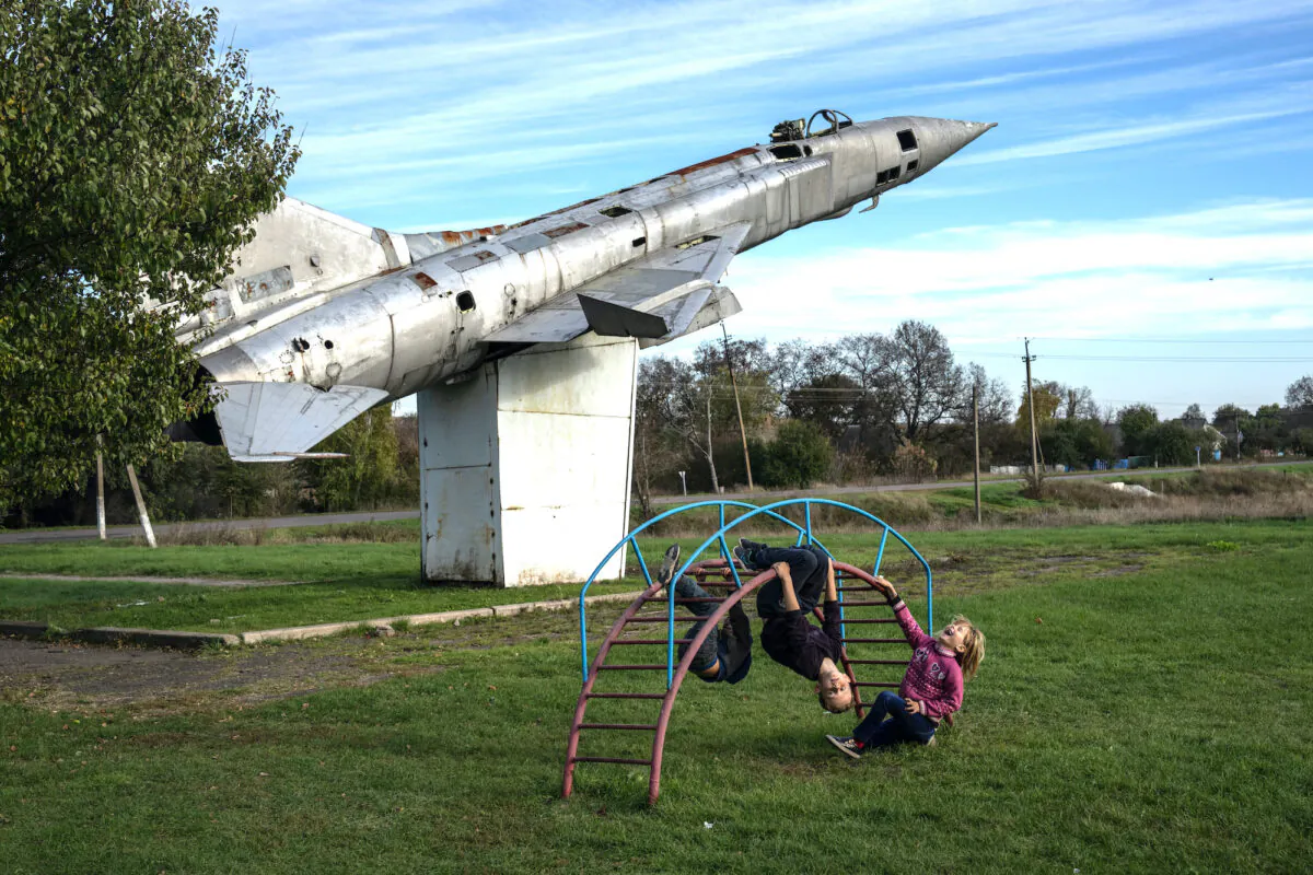 Children play in a park next to a life-size replica of a Soviet-era Sukhoi Su-15 fighter jet on October 19, 2022 in Shostakivka, Donetsk oblast, Ukraine. Russia's president Vladimir Putin today imposed martial law on the four Ukrainian regions occupied by Russian forces as large numbers of civilians were being moved out of the Kherson area ahead of a Ukrainian offensive. (Carl Court/Getty Images)