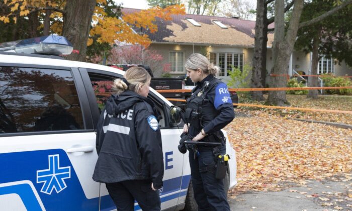 Police survey the scene where two people were found dead, Oct. 20, 2022 in L'Île-Bizard, Que. (The Canadian Press/Ryan Remiorz)
