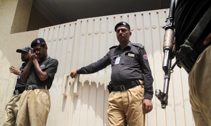 2016 年 7 月 16 日，巴基斯坦警察在木尔坦的一处房产外站岗。（SHAHID SAEED MIRZA/AFP via Getty Images）