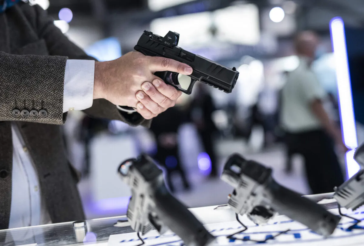 An attendee holds a Walther PDP pistol at a trade show in Ottawa on June 1, 2022. (The Canadian Press/Justin Tang)