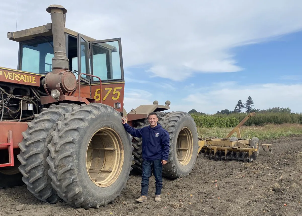 Sixth-generation farmer Alex Wilson stands by a tractor on the family's farmland in Walnut Grove, Sacramento County, Calif. The family's Dead Horse Farm participated in the state's first Delta Drought Response Pilot Program in 2022 by growing safflower instead of fruit. (Courtesy of Alex Wilson)