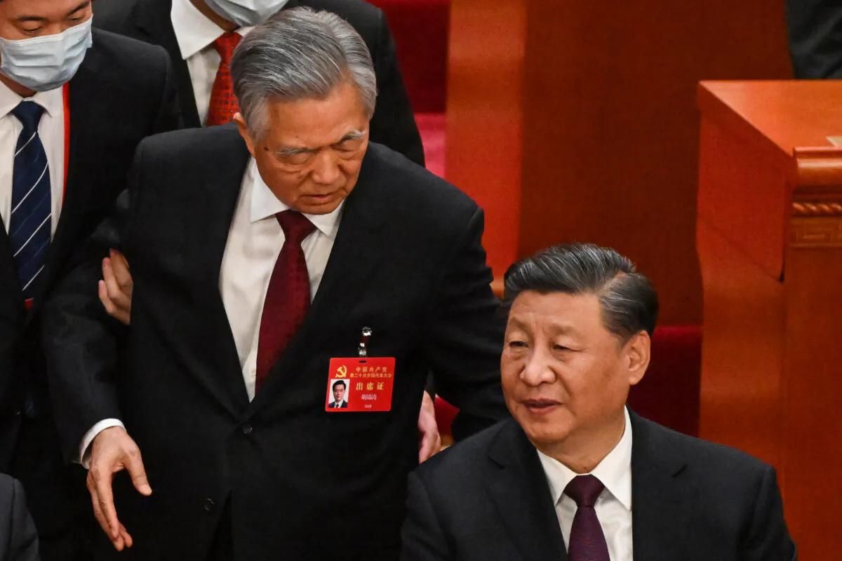 Chinese leader Xi Jinping (R) talks to former leader Hu Jintao as he is assisted to leave from the closing ceremony of the Chinese Communist Party's political conference at the Great Hall of the People in Beijing on Oct 22, 2022. (Noel Celis/AFP via Getty Images)