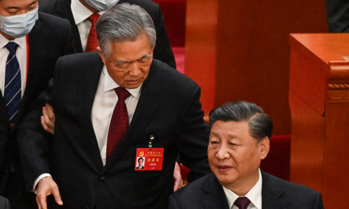 Chinese leader Xi Jinping (R) talks to former leader Hu Jintao as he is assisted to leave from the closing ceremony of the Chinese Communist Party's political conference at the Great Hall of the People in Beijing on Oct 22, 2022. (Noel Celis/AFP via Getty Images)
