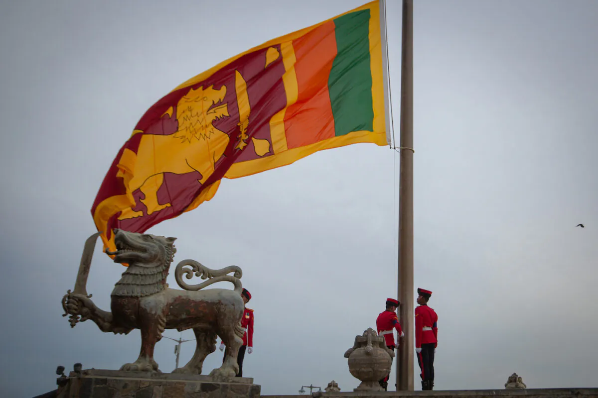 Military personnel in ceremonial uniform lowers the national flag of Sri Lanka at Galle Face Green in Colombo, Sri Lanka on July 17, 2022. (Abhishek Chinnappa/Getty Images)