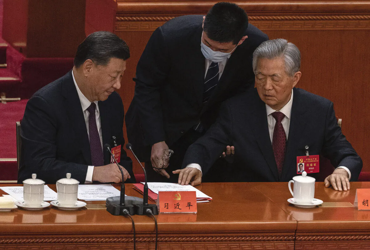 Chinese leader Xi Jinping looks on as former leader Hu Jintao (R) gestures as he is helped to leave early from the closing session of the 20th Chinese Communist Party Congress at The Great Hall of People in Beijing, on Oct. 22, 2022. (Kevin Frayer/Getty Images)