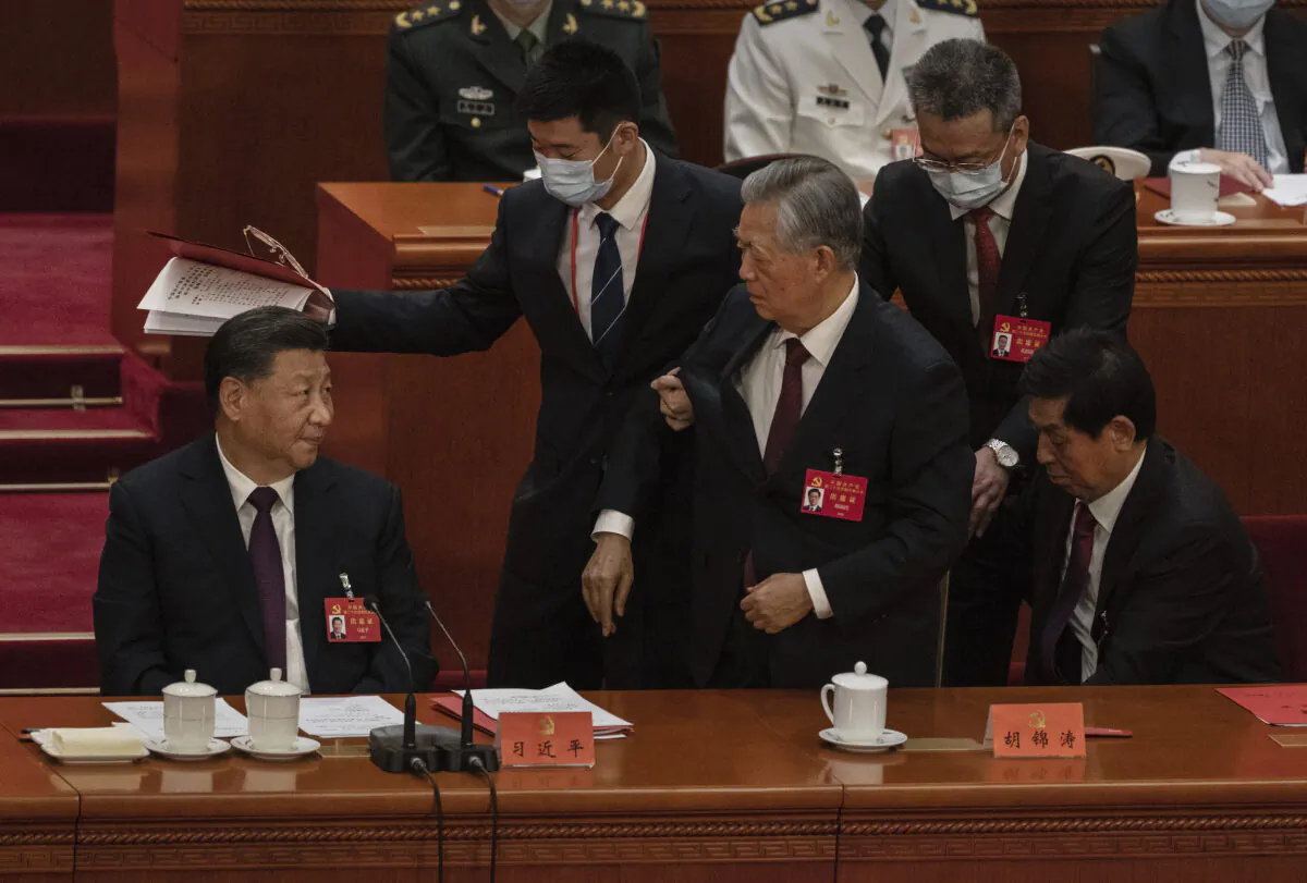 Chinese President Xi Jinping (L) looks on as former President Hu Jintao is helped to leave early from the closing session of the 20th National Congress of the Communist Party of China, at the Great Hall of the People in Beijing, on Oct. 22, 2022. (Kevin Frayer/Getty Images)