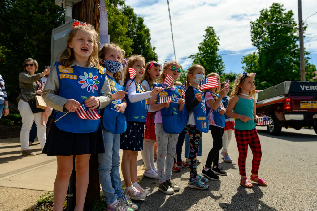 Girl Scouts in Troop 52368 wait for candy and watch parade marchers during the 2021 Oakmont-Verona Memorial Day Parade in Oakmont, Pennsylvania, on May 31, 2021. (Jeff Swensen/Getty Images)