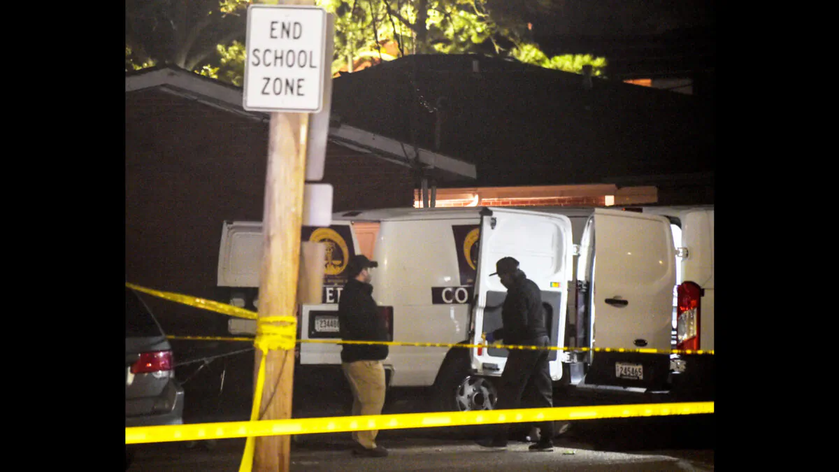 Members of the New Orleans Police Department and Coroner's office respond to a triple homicide in the 4100 block of Encampment Street in New Orleans on March 21, 2022. (Max Becherer/The Times-Picayune/The New Orleans Advocate via AP)