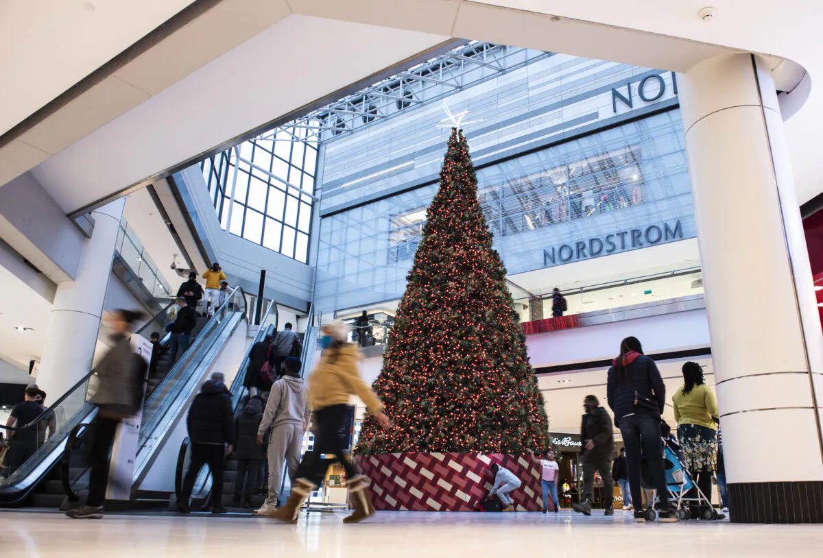 People pass a large Christmas tree as they go shopping on Christmas Eve at a mall in Ottawa on Dec. 24, 2020. (Justin Tang/The Canadian Press)