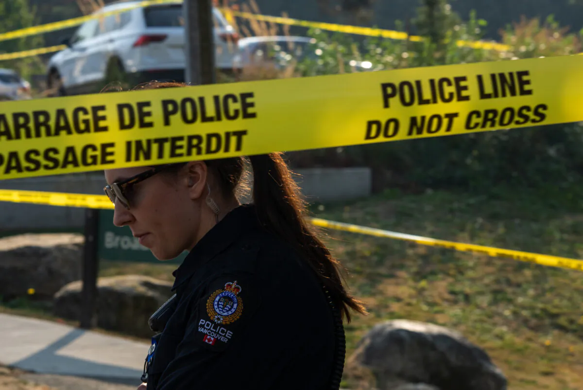 A officer with the Vancouver Police Department is seen near a homeless encampment where a female member of the RCMP was stabbed to death in Burnaby, B.C., Oct. 18, 2022. (The Canadian Press/Jonathan Hayward)