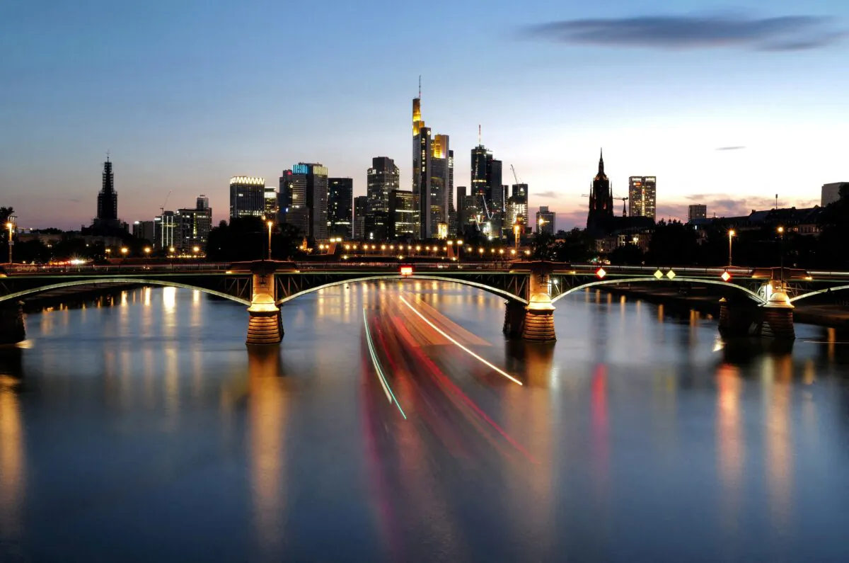 The sun sets behind the skyline of Frankfurt, Germany, on July 5, 2022. (Kai Pfaffenbach/Reuters)