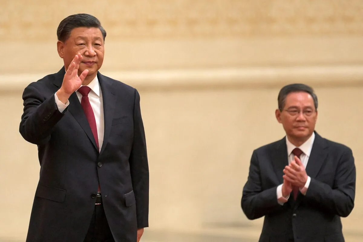 Chinese leader Xi Jinping (L) waves next to Li Qiang, a member of the Chinese Communist Party's new Politburo Standing Committee, the nation's top decision-making body, as they meet the media in the Great Hall of the People in Beijing on Oct. 23, 2022. (Wang Zhao/AFP via Getty Images)