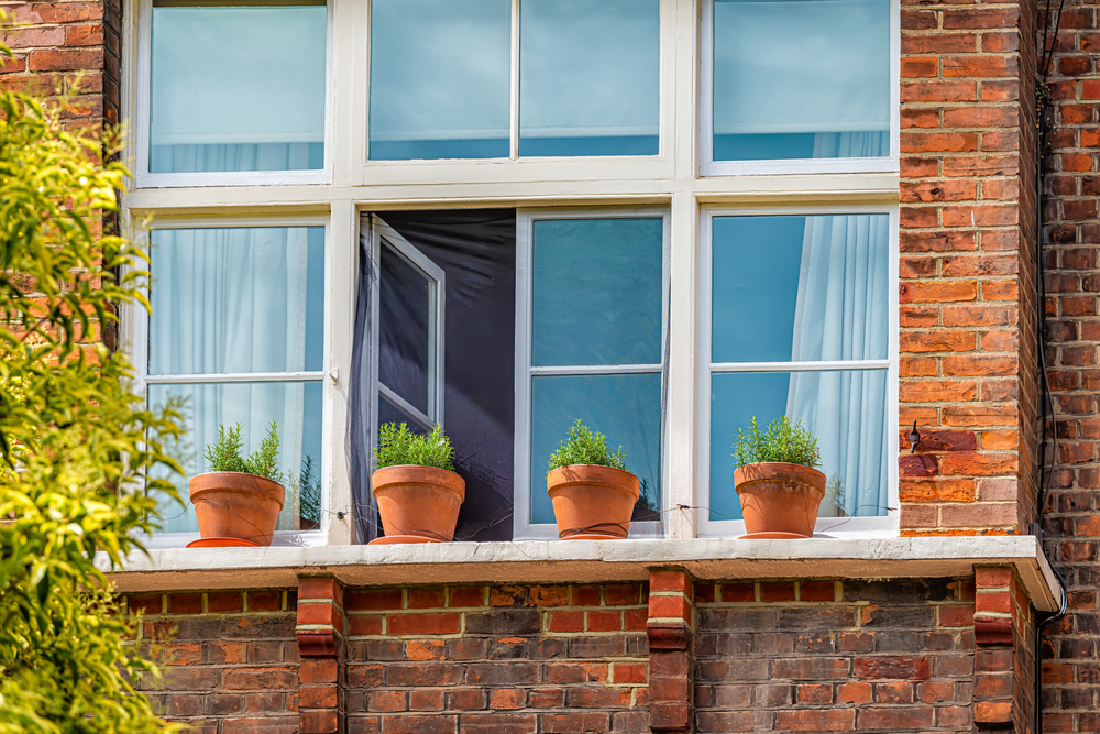 Window,Sill,Of,Red,Brick,Flat,Apartment,Building,With,Gardening