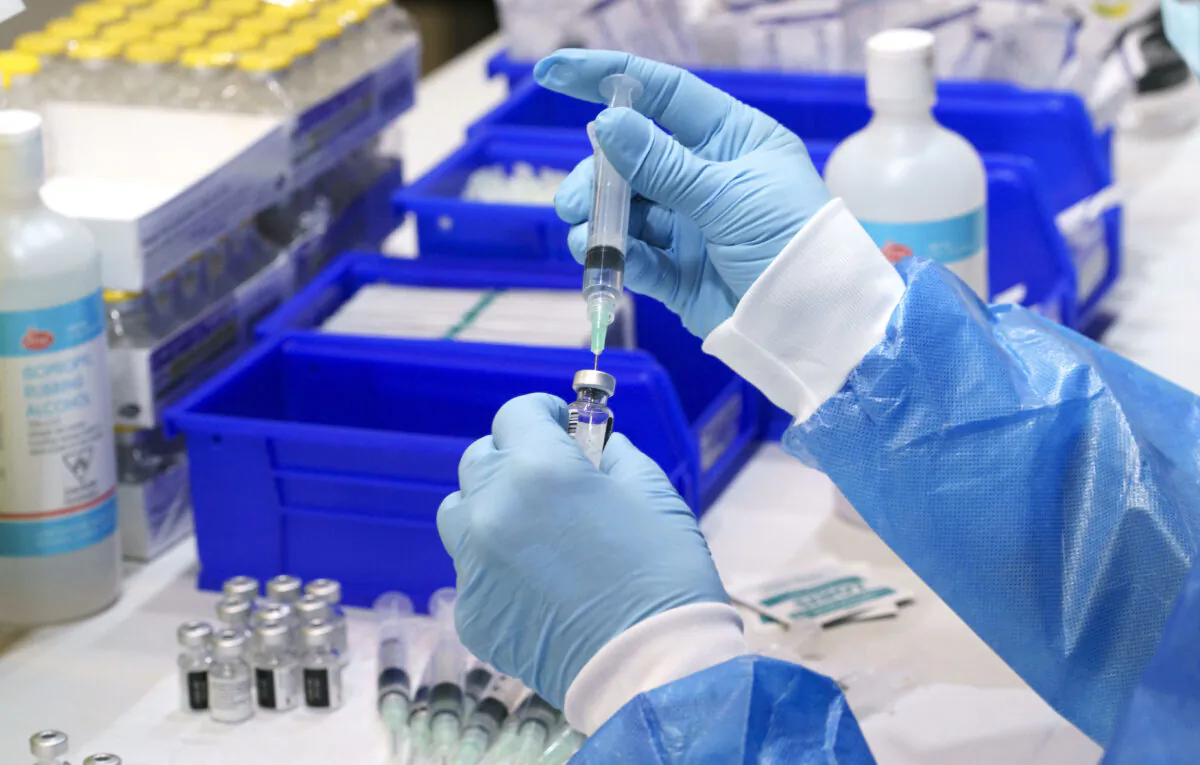 A health worker prepares a syringe with COVID-19 vaccine at a vaccination clinic in Montreal on March 15, 2021. (The Canadian Press/Paul Chiasson)