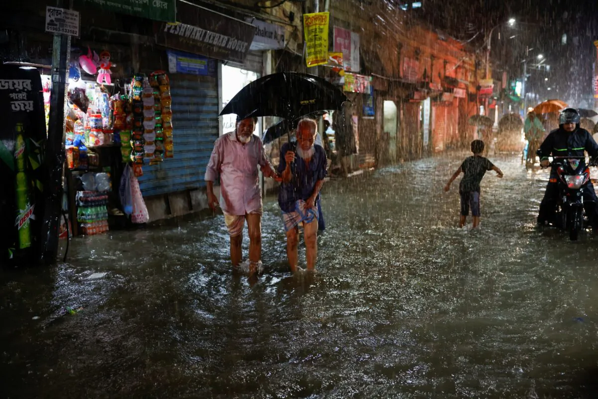 People wade through a flooded street amid continuous rain before the Cyclone Sitrang hits Dhaka, Bangladesh, on Oct. 24, 2022. (Mohammad Ponir Hossain/Reuters)