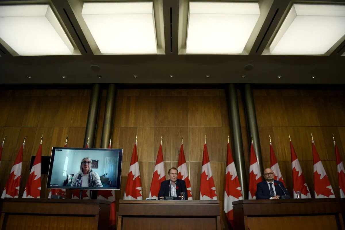 Minister of Crown-Indigenous Relations Marc Miller, centre, Minister of Justice David Lametti and and Minister of Indigenous Services Patty Hajdu, appearing via video conference at left, participate in a news conference regarding the order from the Canadian Human Rights Tribunal to compensate Indigenous children and their families, in Ottawa, on Oct. 29, 2021. (The Canadian Press/Justin Tang)

