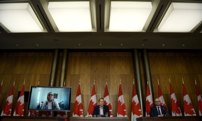 Minister of Crown-Indigenous Relations Marc Miller, centre, Minister of Justice David Lametti and and Minister of Indigenous Services Patty Hajdu, appearing via video conference at left, participate in a news conference regarding the order from the Canadian Human Rights Tribunal to compensate Indigenous children and their families, in Ottawa, on Oct. 29, 2021. (The Canadian Press/Justin Tang)
