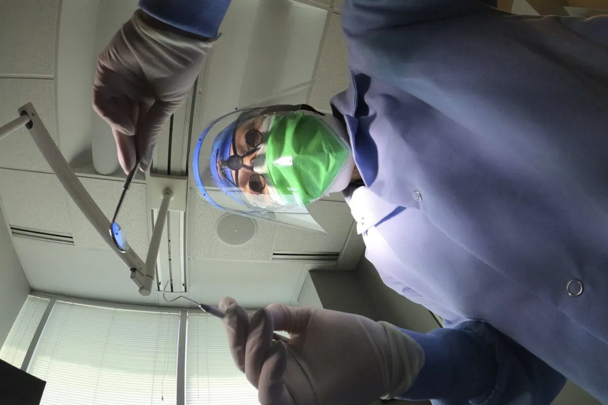 A dentist holds instruments in Skokie, Ill., on June 12, 2020. (The Canadian Press/Charles Rex Arbogast)
