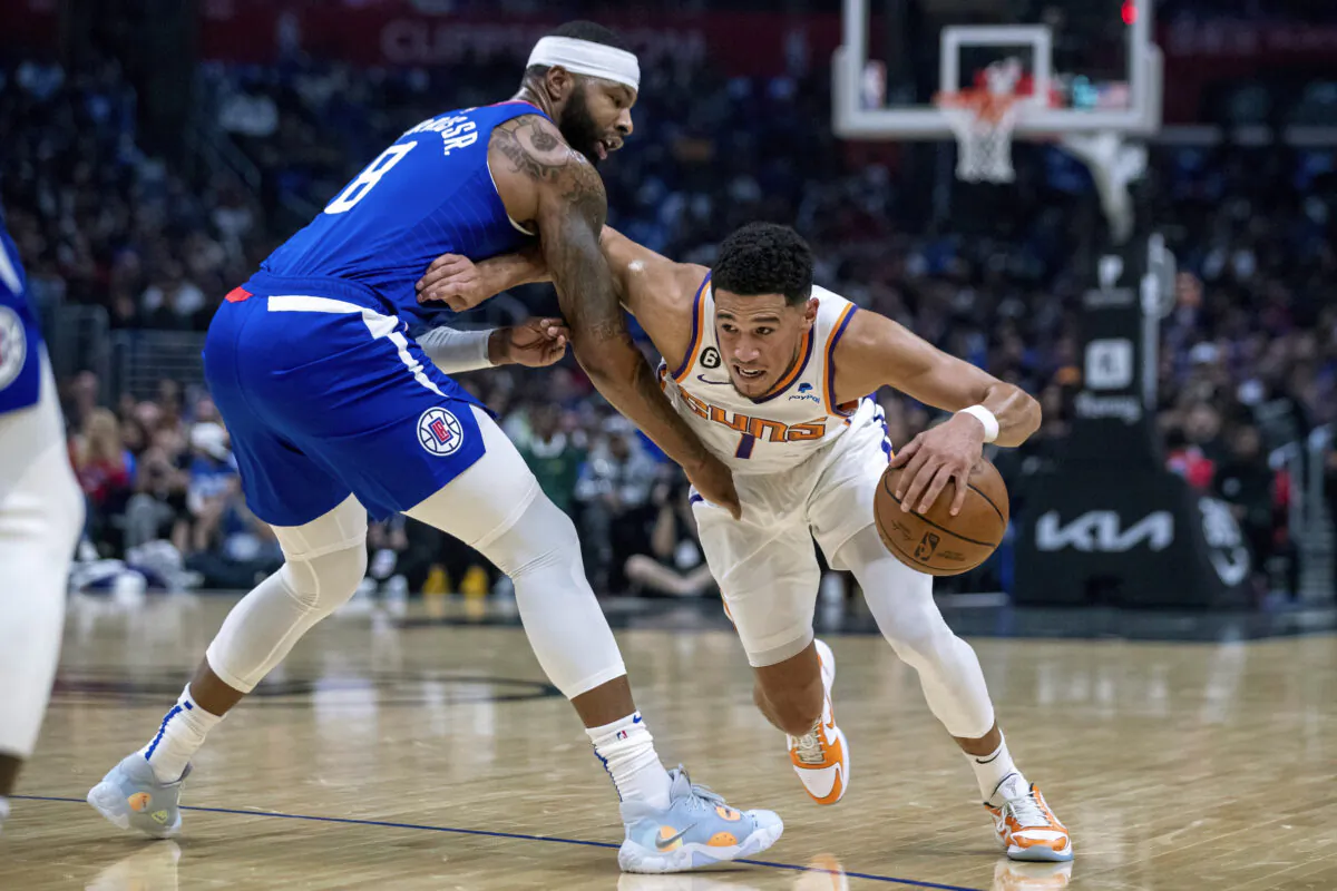Phoenix Suns guard Devin Booker, right, drives past Los Angeles Clippers forward Marcus Morris Sr., during the first half of an NBA basketball game, in Los Angeles, on Oct. 23, 2022. (Alex Gallardo/AP Photo)