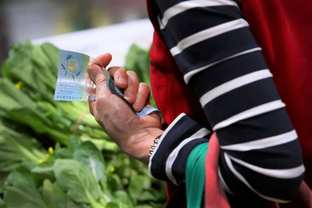 A shopper holds money to make a purchase of fruit and vegetable produce at Paddy's Market in Sydney, Australia, on Oct. 22, 2022. (Lisa Maree Williams/Getty Images)