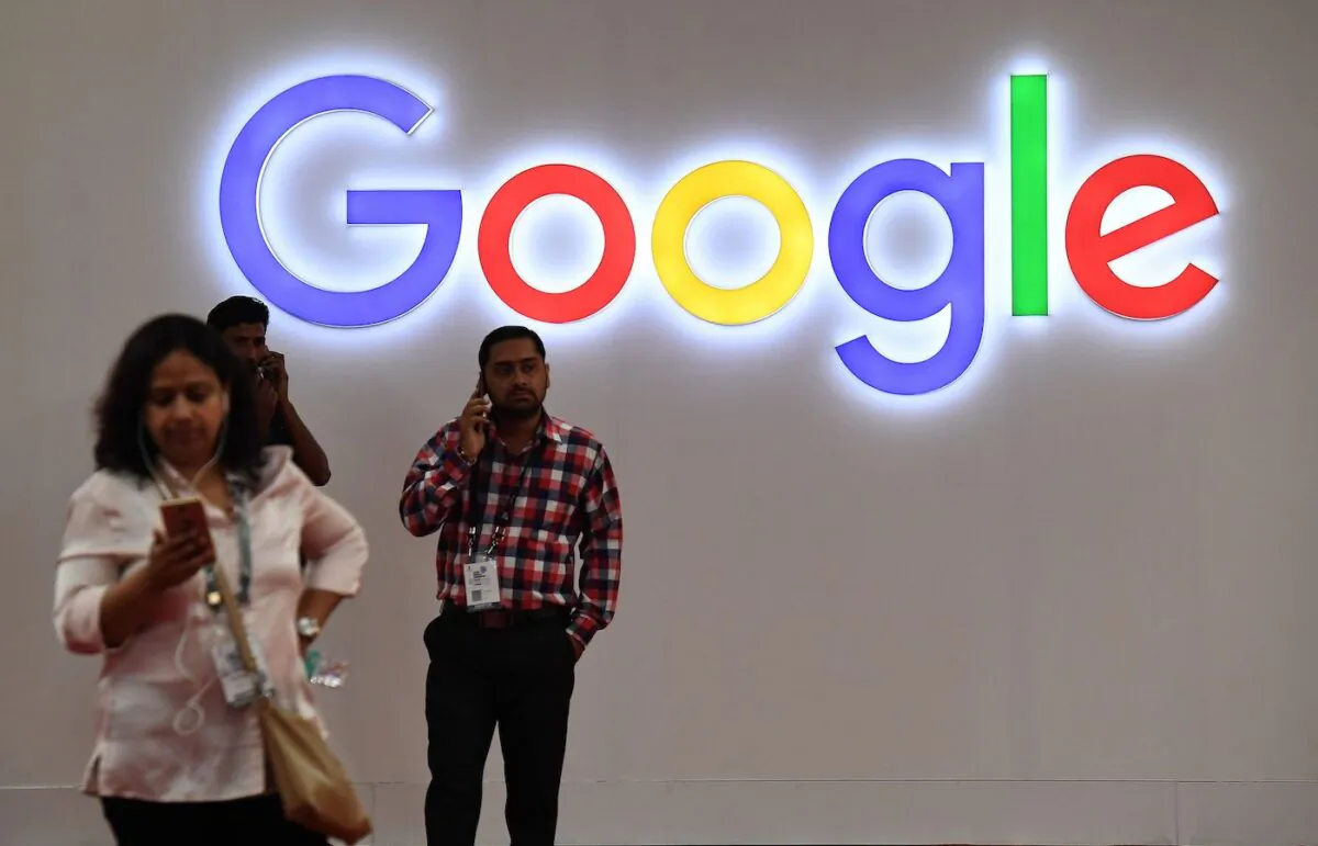 Indian visitors talk on their mobile phones outside the Google stall at the India Mobile Congress in New Delhi on Sept. 27, 2017. (Prakash Singh/AFP via Getty Images)