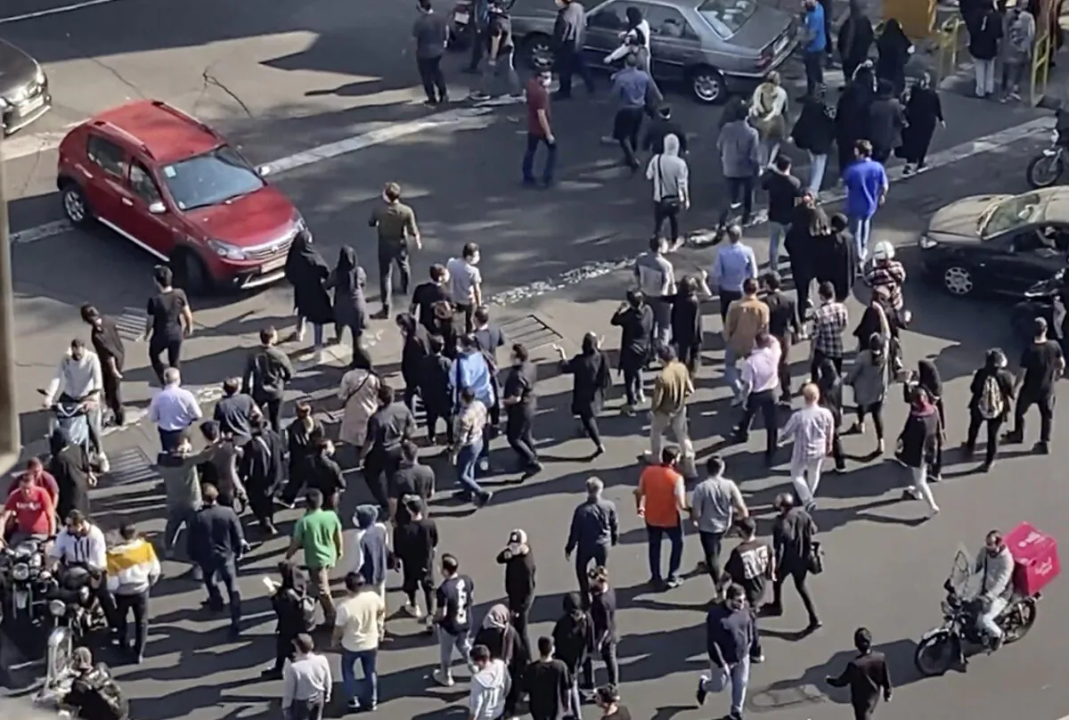 People block an intersection during a protest to mark 40 days since the death in custody of 22-year-old Mahsa Amini, whose tragedy sparked Iran's biggest anti-government movement in over a decade, in Tehran, Iran, on Oct. 26, 2022, in this frame grab from video taken by an individual not employed by the Associated Press and obtained by the AP outside Iran. (AP Photo)