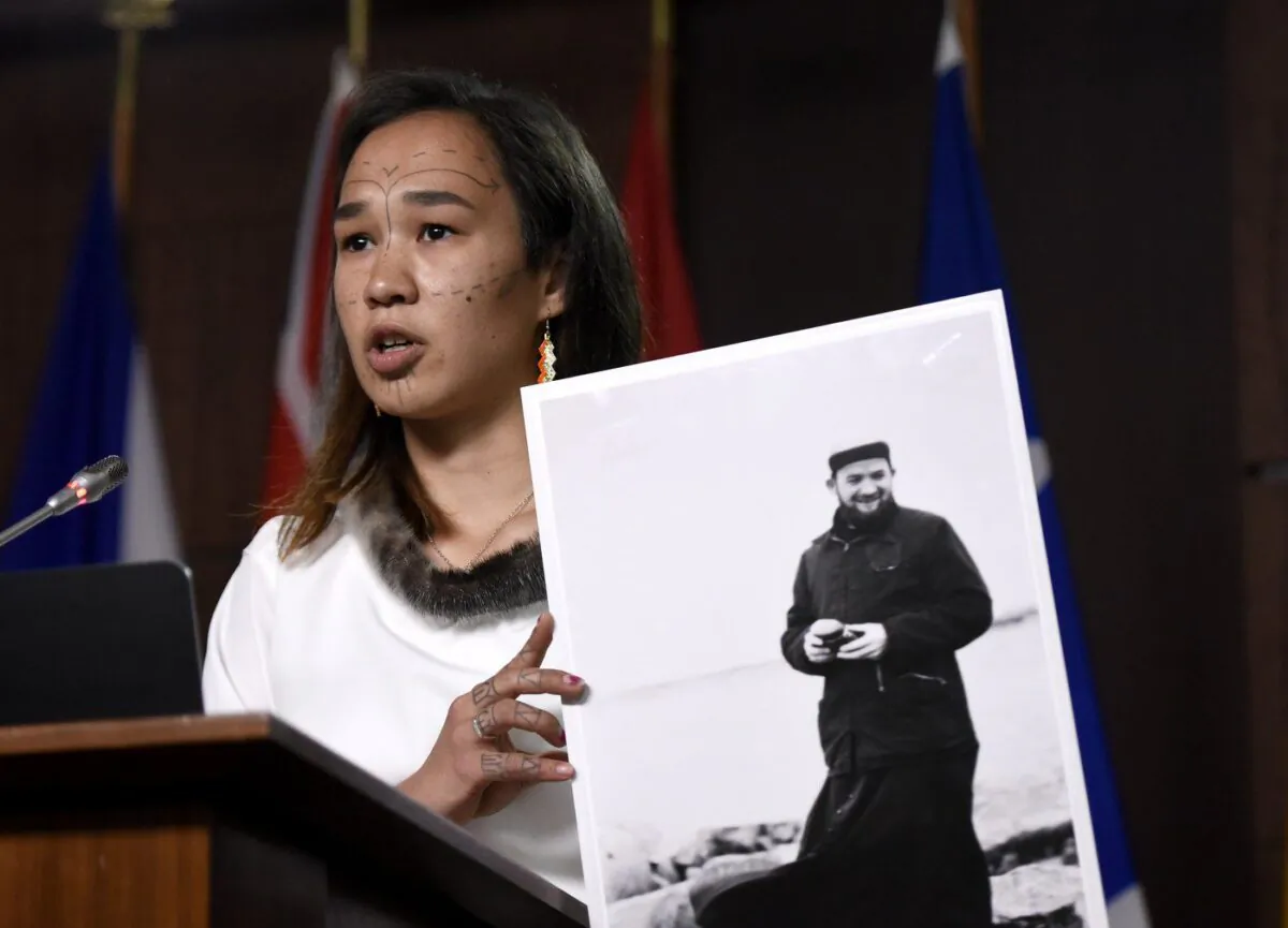 Former NDP MP Mumilaaq Qaqqaq holds a photo of Johannes Rivoire, a priest who is wanted in Canada but resides in France, during a news conference on Parliament Hill in Ottawa, on July 8, 2021. (The Canadian Press/Justin Tang)
