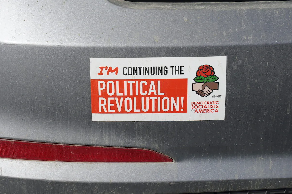 A pro-socialism bumper sticker in the employee parking lot of a high school in Grants Pass, Ore., on Oct. 18, 2022. (Jackson Elliott/The Epoch Times)