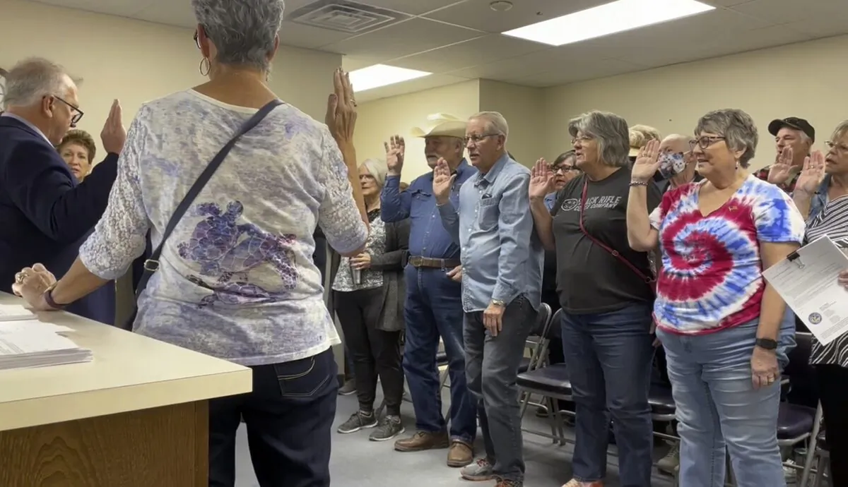 Nye County Clerk Mark Kampf (far L), in suit, swears in a group of residents who will hand count early ballots cast in the rural county about halfway between Las Vegas and Reno, in Pahrump, Nev., on Oct. 26, 2022. (Gabe Stern/AP Photo)