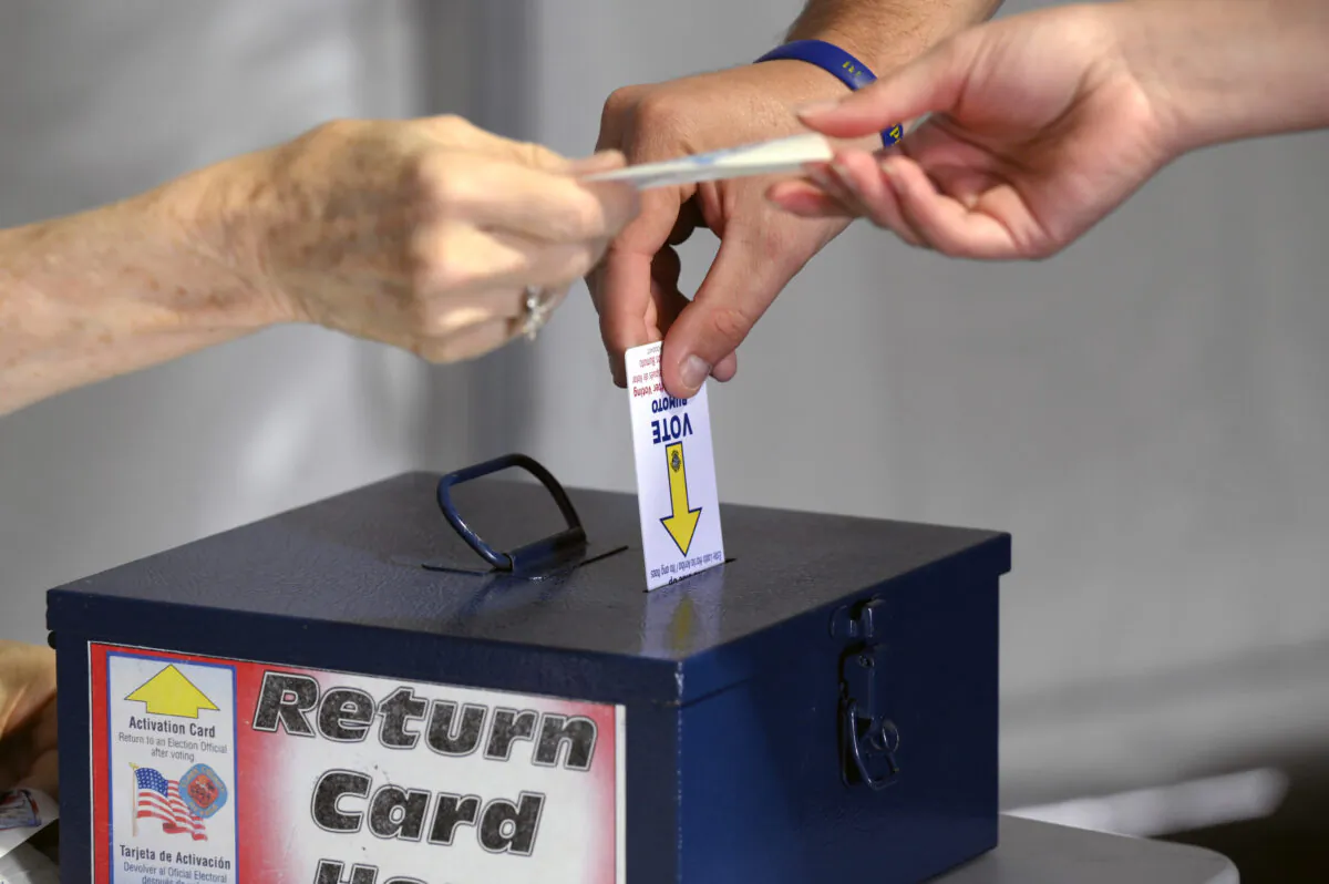 A voter returns a voter card after casting their ballot on the first day of in-person early voting inside a tent at a shopping center in Las Vegas on Oct. 22, 2022. (David Becker/Getty Images)