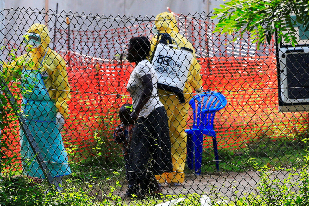 A woman and her child arrive for ebola related investigation at the health facility at the Bwera general hospital near the border with the Democratic Republic of Congo in Bwera, Uganda, on June 14, 2019. (James Akena/Reuters)