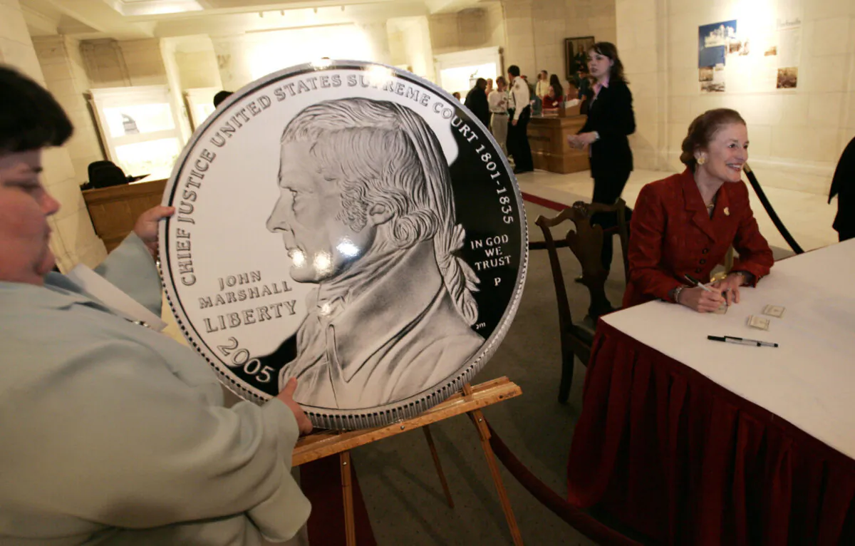 Supreme Court Justice Stephen Breyer; Henrietta Fore, director of the U.S. Mint; and Frank Jones, president of the Supreme Court Historical Society hold a ceremony to unveil the Chief Justice John Marshall Silver Dollar at the Supreme Court Upper Great Hall in Washington, D.C., on May 4, 2005. The new silver dollar commemorates the 250th anniversary of Marshall's birthday, Sept. 24, 1755, and it is the first coin produced by the U.S. Mint honoring a Supreme Court Justice. (Chip Somodevilla/Getty Images)