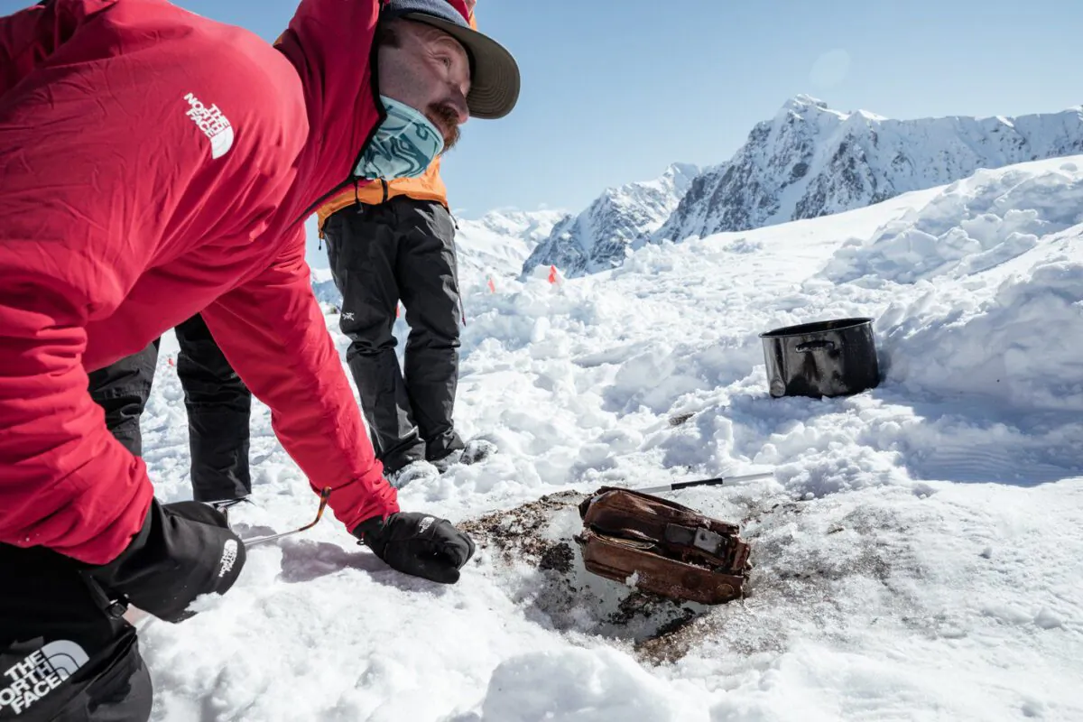 Griffin Post looks over parts of an 85-year-old cache belonging to famed explorer Bradford Washburn in a handout photo. Post led the team that discovered the cache on Yukon's Walsh glacier. (The Canadian Press/Leslie Hittmeier)
