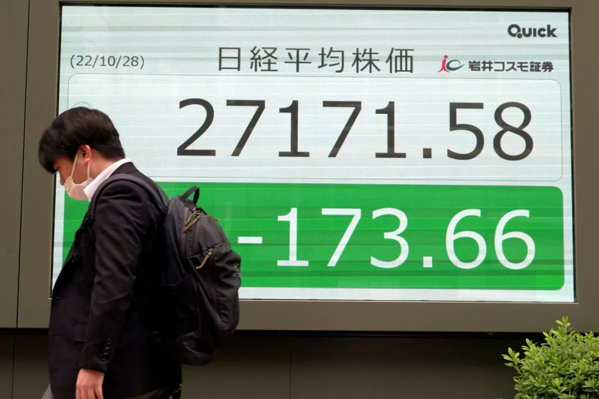 A person walks in front of an electronic stock board showing Japan's Nikkei 225 index at a securities firm in Tokyo on Oct. 28, 2022. (Eugene Hoshiko/AP Photo)