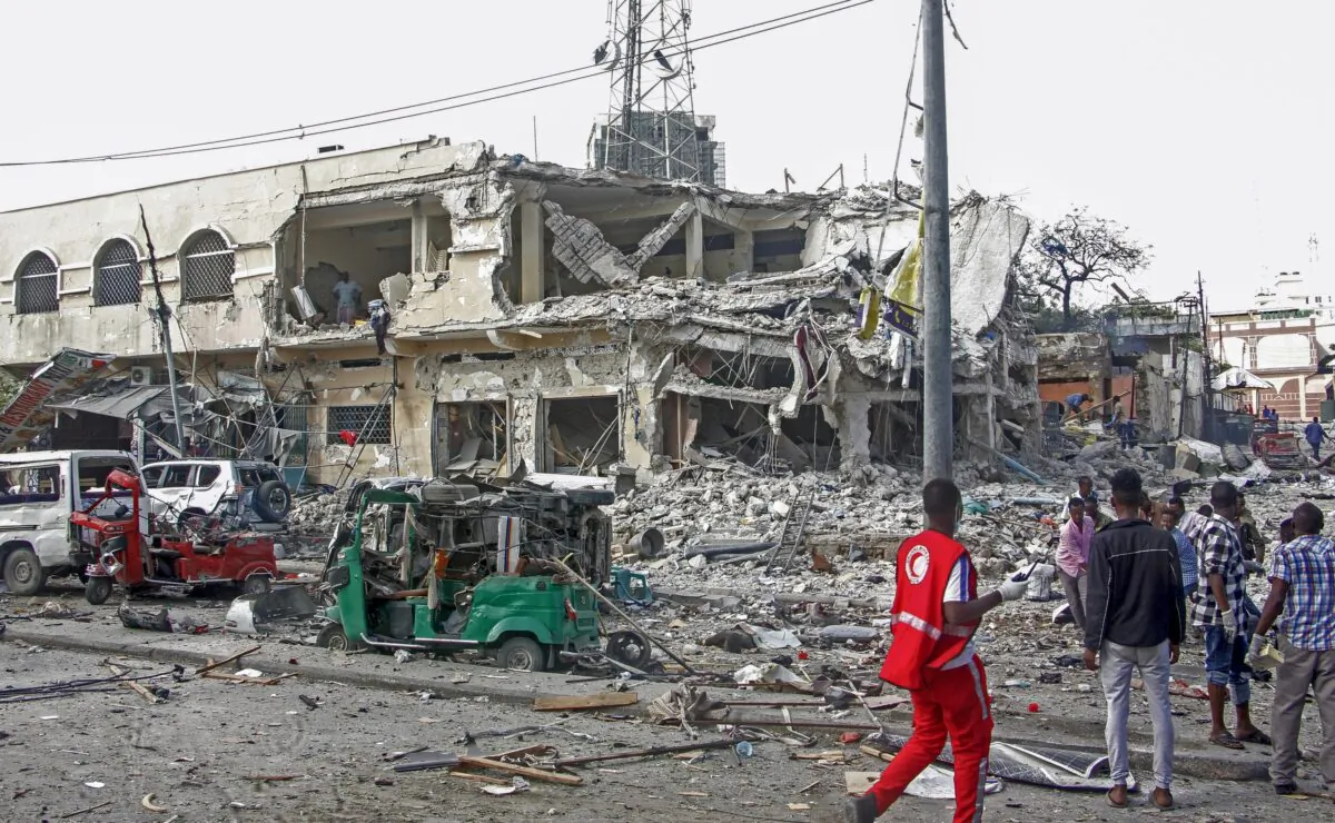 People observe a destroyed building and vehicles at the scene of a two car bombs attack in Mogadishu, Somalia, on Oct. 29, 2022. (Farah Abdi Warsameh/(AP Photo)