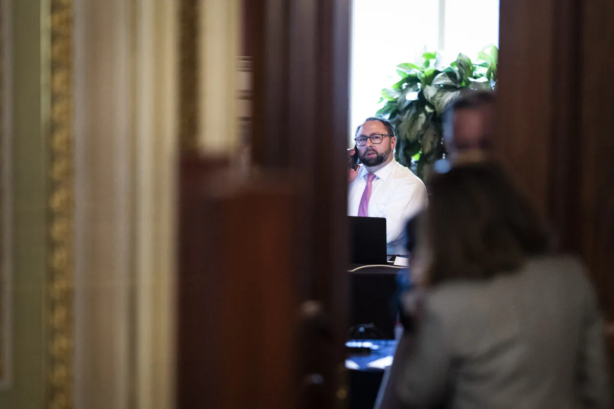 Jason Miller talks on the phone in a meeting room on Capitol Hill on Feb. 12, 2021. (Jabin Botsford/Pool/AFP via Getty Images)