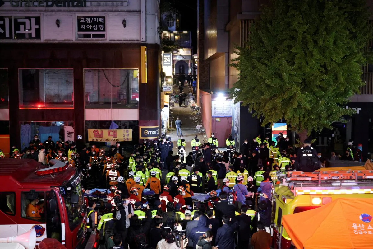 Rescue teams and firefighters work at the scene where dozens of people were injured in a late-night stampede during a Halloween festival in Seoul, South Korea, on Oct. 30, 2022. (Kim Hong-ji/Reuters)