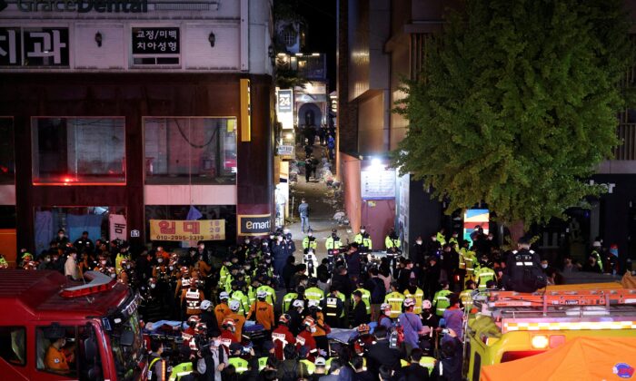 2022 年 10 月 30 日，在韩国首尔举行的万圣节节日期间，数十人在深夜踩踏事件中受伤，救援队和消防员在现场工作。（Kim Hong-ji/路透社）