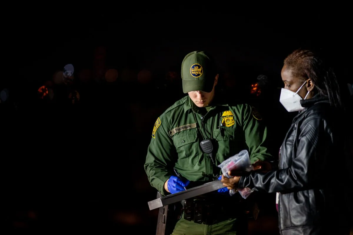 A Border Patrol officer processes a migrant woman who crossed the Rio Grande into the U.S. in Roma, Texas, on May 5, 2022. (Brandon Bell/Getty Images)