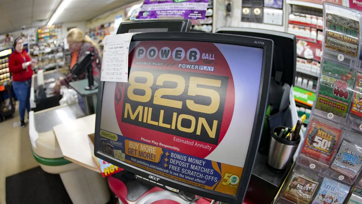 Customers pay for their groceries next to the lottery ticket display showing the jackpot amount for the Oct. 29 drawing of the Powerball lottery at a market in Prospect, Pa., on Oct. 28, 2022. (Keith Srakocic/AP Photo)