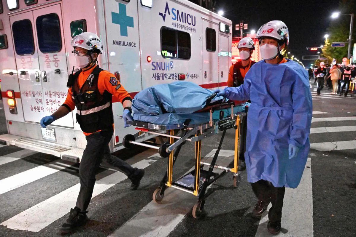 The body of a victim of a Halloween crush, which left at least 120 people dead, is transported on a stretcher in the district of Itaewon in Seoul on Oct. 30, 2022. (JUNG YEON-JE/AFP via Getty Images)