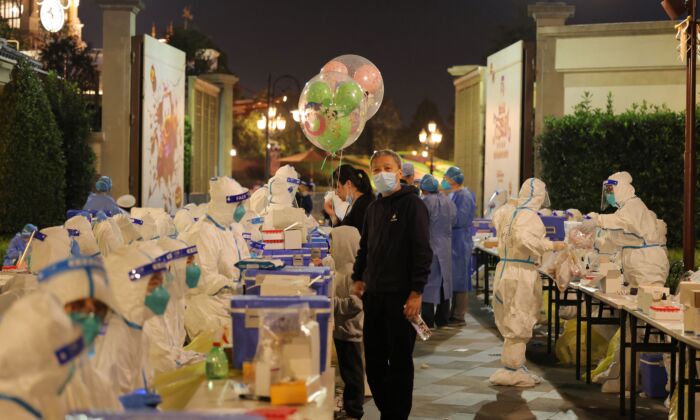 医务人员于 2021 年 10 月 31 日在上海迪士尼乐园对游客进行 Covid-19 冠状病毒检测。（-/法新社通过 Getty Images）