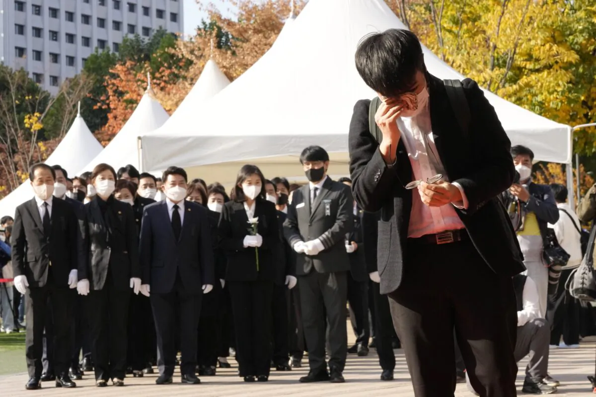 A mourner wipes his tear as he pays a silent tribute for victims of a deadly accident following Saturday night's Halloween festivities, at a joint memorial altar for victims at Seoul Square in Seoul, South Korea, on Oct. 31, 2022. (Ahn Young-joon/AP Photo)