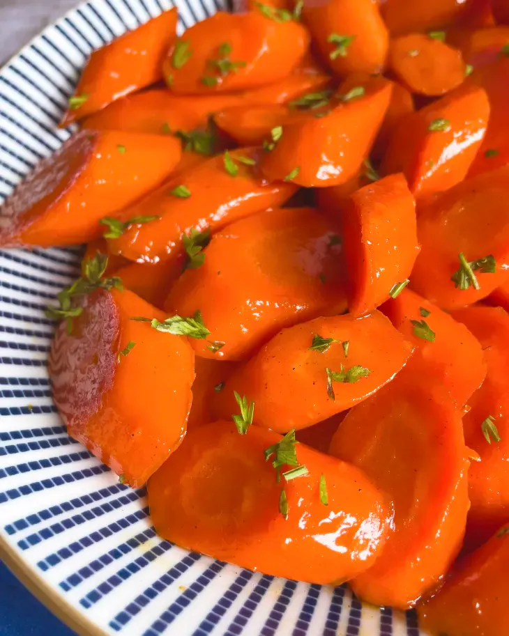 A delicious, syrupy glaze helps to enhance the natural sweetness of carrots in this stunning, glossy, bejeweled vegetable side dish. (Tara Holland/TNS)