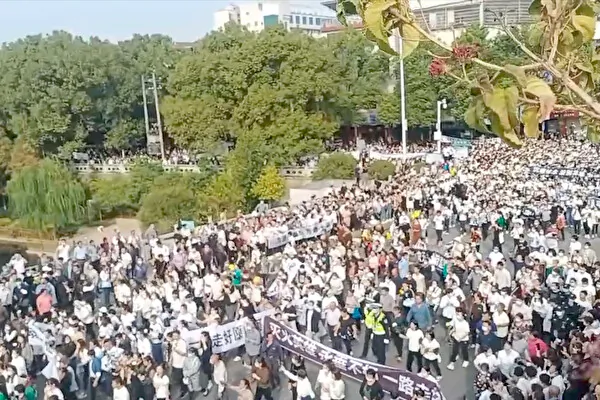 Tens of thousands of local residents gather and march in a memorial for two firefighters killed in the wildfire in Xintian County, Hunan Province, on Oct. 25, 2022. The wildfire broke out on Oct. 17, lasted for more than seven days, and engulfed half of the county, but the news was censored to ensure the party congress would be held without any disturbance. (Video screenshot)